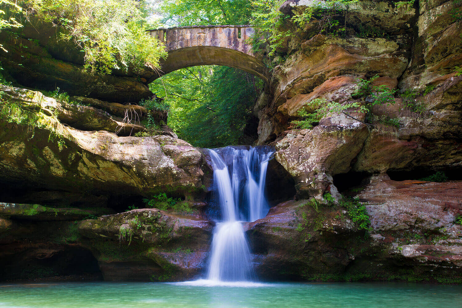 waterfall with bridge above in hocking hills state park - photo by wnder the map