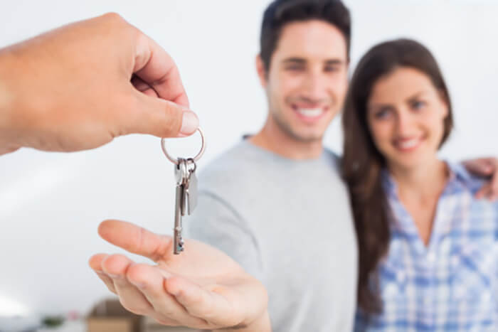 man and woman couple receiving keys to their new home 