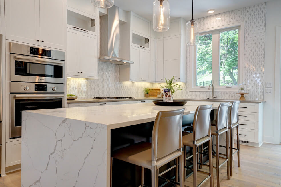 white kitchen with marble island and tan bar stools - chris gorman homes in Cincinnati